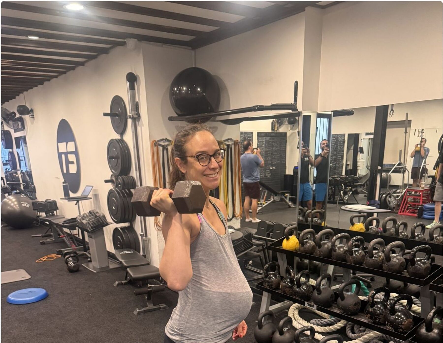 Prenatal client lifting dumbbells at TS Fitness studio